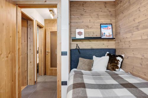 a bedroom with a blue bed and wooden walls at La Casa di Larice in Val di Sole in Rabbi