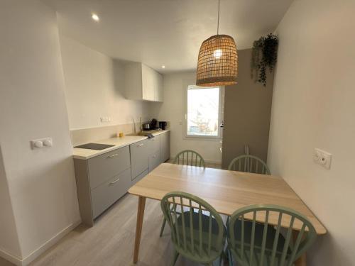 ヴァルラ・プラージュにあるValras-Loc L-Hippocampe, tout a pied - 2 chambresの木製のテーブルと緑の椅子のあるキッチン