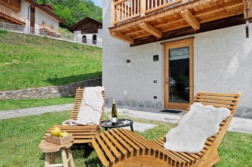 two chairs and a table with a bottle of wine at La Casa di Larice in Val di Sole in Rabbi