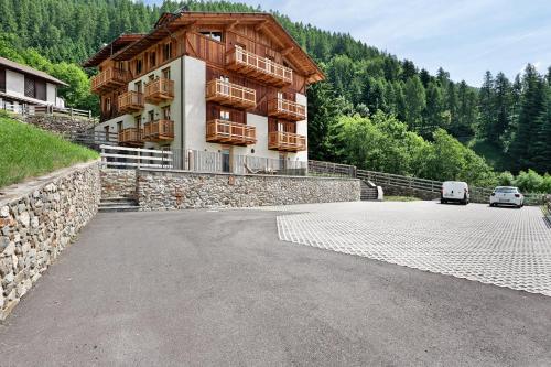 a building with two cars parked in front of it at La Casa di Larice in Val di Sole in Rabbi