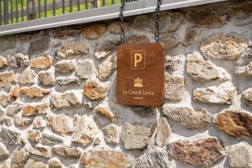 a sign on the side of a stone wall at La Casa di Larice in Val di Sole in Rabbi