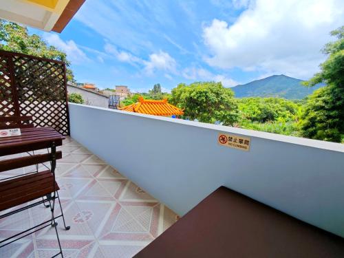 a balcony with a view of the mountains at Cloud Tree Inn Boutique Guesthouse XiChong DaPeng ShenZhen 深圳大鹏西涌云树里民宿Yun Shu Li in Shenzhen