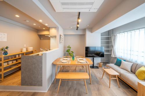 a living room with a table and a couch at Starry Stay Suite Improve Nishimagome in Tokyo