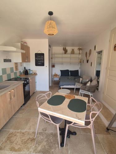 a kitchen and a living room with a table and chairs at Gites Colline De Sollies in Salernes