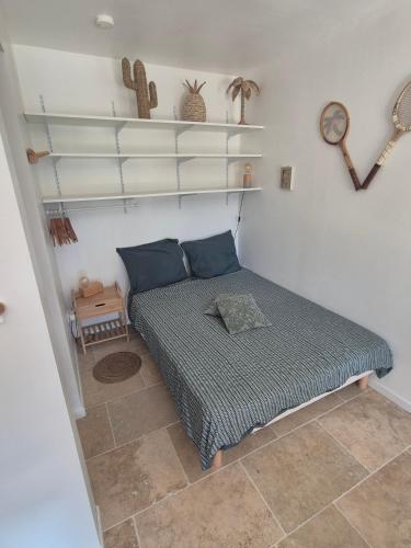 a small bedroom with a bed and shelves at Gites Colline De Sollies in Salernes