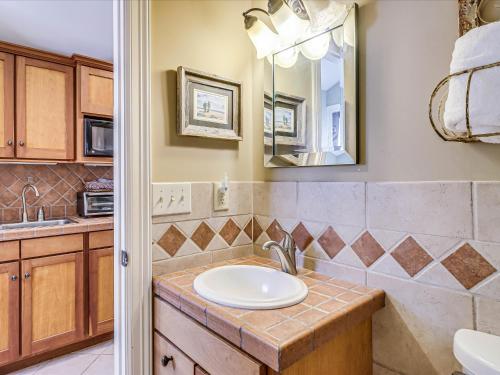 un baño con lavabo y espejo en Rockport Bungalow, en Rockport