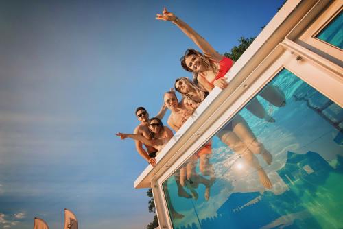a group of people jumping into a swimming pool at SCANDINAVIA House - dom z jacuzzi in Zator