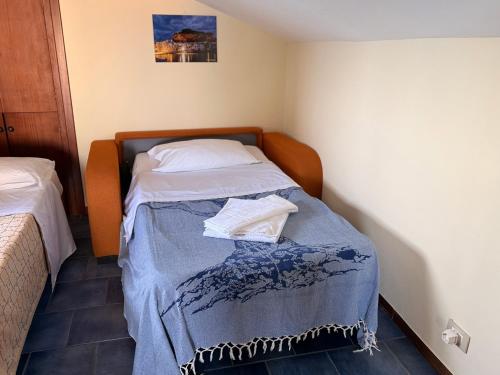 a small bedroom with a bed with a blue blanket at MiraMare Residence Cefalú in Cefalù