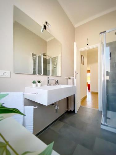 a bathroom with a white sink and a mirror at Comodo e Pratico nel Cuore pulsante di Pisa in Pisa