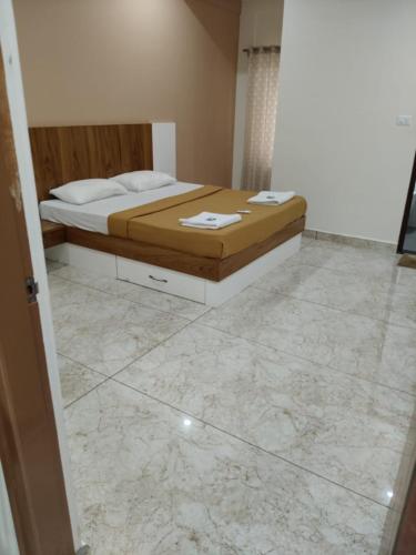 a bedroom with a bed and a marble floor at Nandan Suits in Mysore