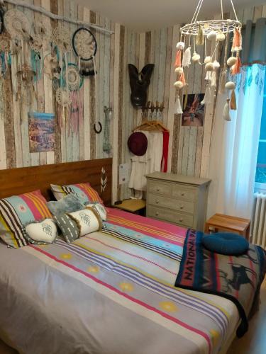 - une chambre avec un lit, une commode et une horloge dans l'établissement Jadis sous la gloriette, à Sancoins