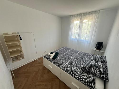 une petite chambre avec un lit et une fenêtre dans l'établissement Appartement lumineux, spacieux et idéalement situé, à Saint-Raphaël