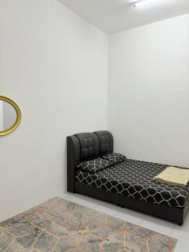a black bed sitting in a corner of a room at Al Marwa Homestay Jerantut in Jerantut