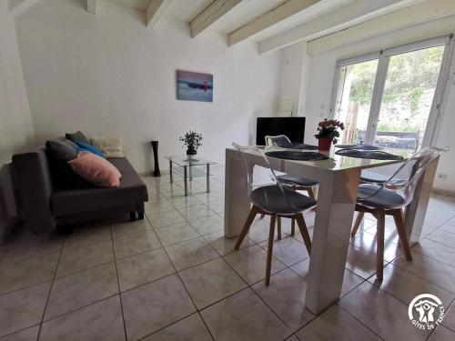 un salon avec une table et un canapé dans l'établissement Du côté de chez Rosélia, à Bédarieux