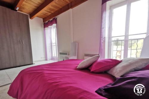 a bedroom with a large bed with pink sheets and pillows at Du côté de chez Rosélia in Bédarieux