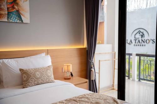 a bedroom with a bed and a window at La Tano's Canggu in Canggu