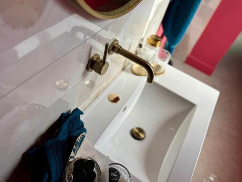 a white bathroom sink with a faucet on it at Add'Or, Suite et Spa in Beugny