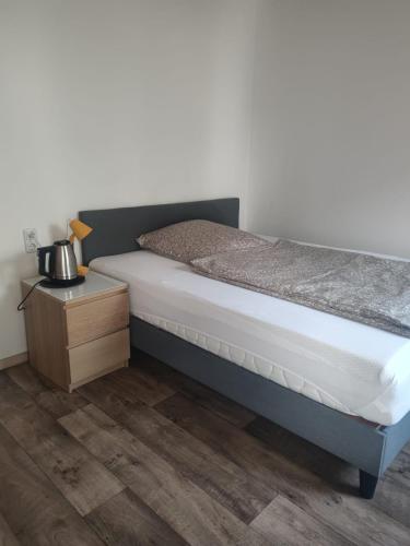 a bed in a room with a nightstand and a bed sidx sidx at Monteurzimmer Mühlheim am Main Nähe S-Bahn in Mühlheim