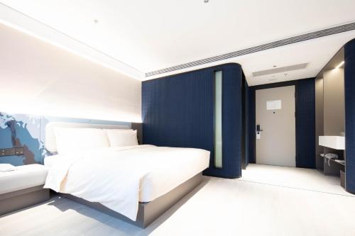 a bedroom with a bed and a blue wall at Atour Light Hotel Hangzhou West Lake Lakeside Pedestrian Street in Hangzhou