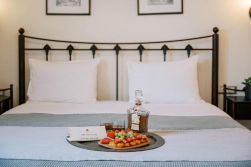 a tray with fruit and a bottle on a bed at Zacosta Villa Hotel in Rhodes Town