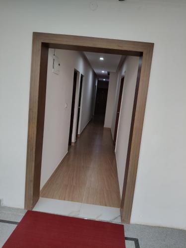 a hallway with a door into a room with a red carpet at Nandan Suits in Mysore