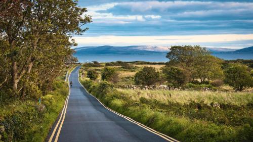 a long road with a person walking down the road at The Twelve Hotel in Barna