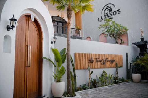 a building with a wooden door and some plants at La Tano's Canggu in Canggu