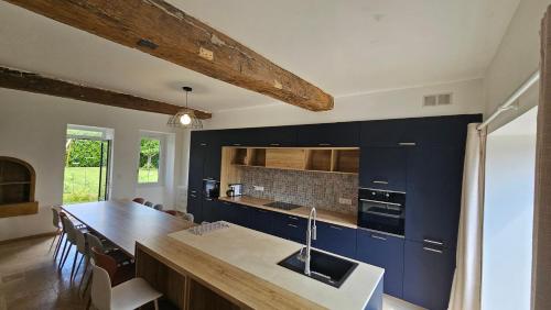 une cuisine avec des placards bleus et un comptoir en bois dans l'établissement gîte parenthèse en morvan, à Magny