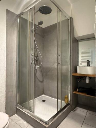 une douche dans une salle de bain avec un lavabo dans l'établissement Le Repaire Sarrecrochet, au Puy-en-Velay