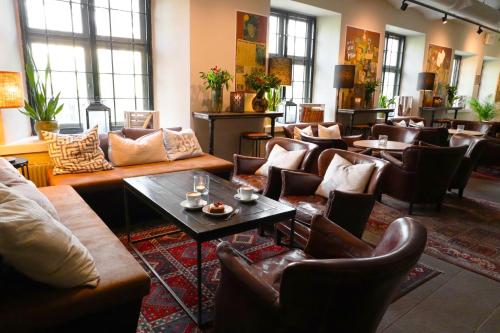 a waiting room with couches and tables and chairs at Långholmen Hotell in Stockholm