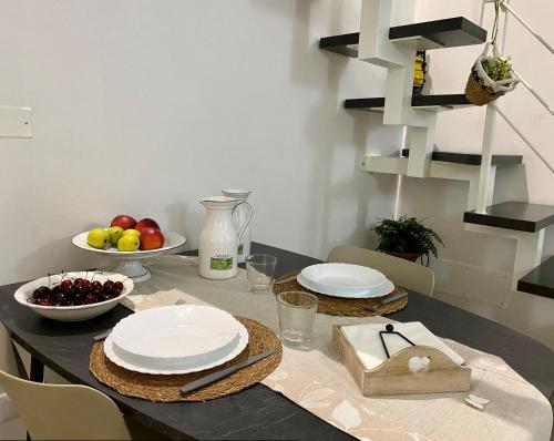 a table with plates and bowls of fruit on it at Casa Astuneon in Ostuni