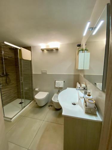 a bathroom with a sink and a toilet and a shower at Casa Astuneon in Ostuni