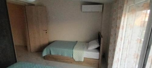 a small bedroom with a bed and a window at Twins house pool 2 in Nikiti