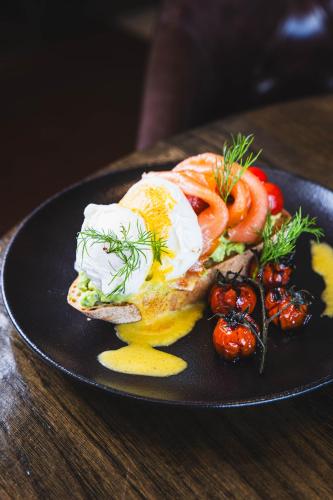 a plate of food with eggs and tomatoes on a table at The Twelve Hotel in Barna