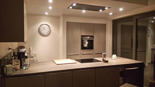 a kitchen with a stove and a clock on the wall at La renaissance in Villers-lʼÉvêque