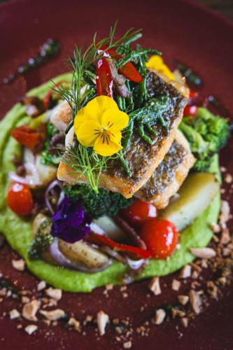 a plate of food with vegetables and a flower on it at The Twelve Hotel in Barna