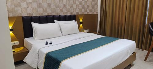 a large white bed in a hotel room at Hotel Shivansh in Veraval
