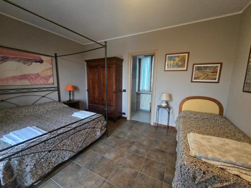 a bedroom with two beds and a window at La Terrazza del Barbaresco in Neviglie