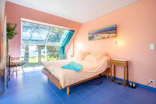 a bedroom with a bed and a window at Coin de paradis face à l'océan in Loctudy