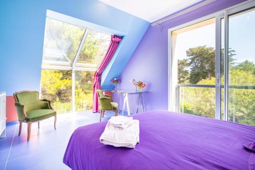 a purple bedroom with a purple bed and large windows at Coin de paradis face à l'océan in Loctudy