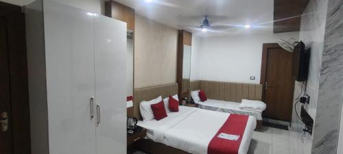 a hotel room with two beds and a television at Hotel New Arcadia in Bhopal