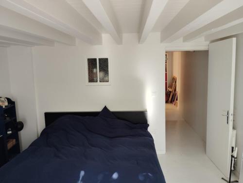 - une chambre avec un lit bleu et un mur blanc dans l'établissement Pretty house, à Bordeaux