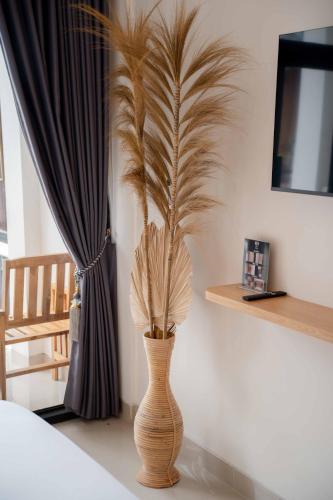 a vase with a plant in it next to a window at La Tano's Canggu in Canggu