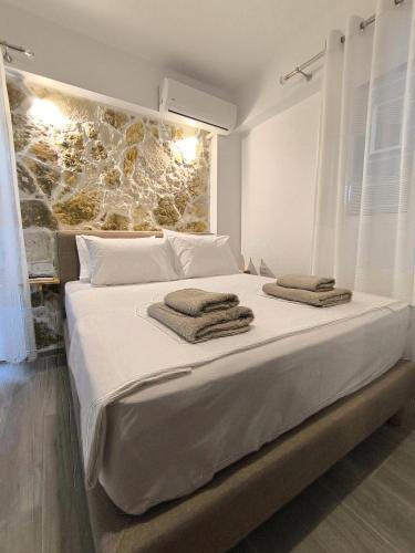 a bedroom with a large white bed with towels on it at MD Luxury Studios in Himare