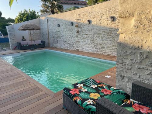 una piscina con una silla y una sombrilla en Maison confortable à Jard-sur-Mer avec grand jardin clôturé, en Jard-sur-Mer