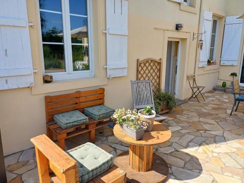 a patio with a table and chairs and a table and bench at L'étoile du matin in Terville