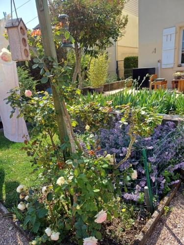 a garden with flowers and a bird house at L'étoile du matin in Terville
