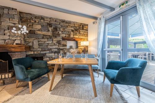 un salon avec une table et deux chaises et un mur en pierre dans l'établissement La Désirade - Hôtel, Spa & Restaurant, à Bangor
