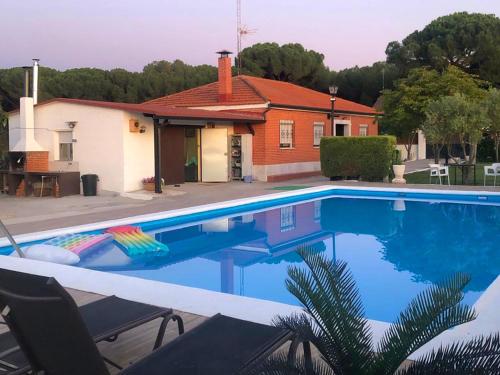 a large swimming pool in front of a house at Villa La Espiga in Valladolid