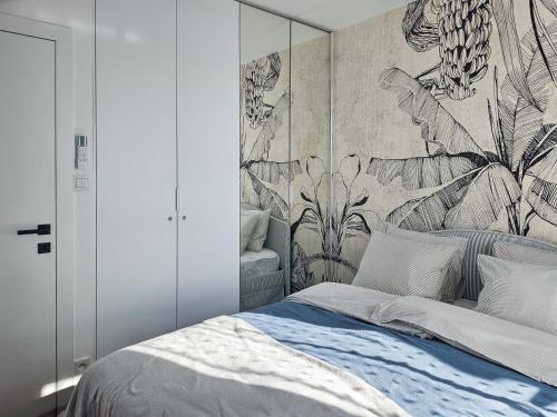 a bedroom with a large bed with a floral wallpaper at Kairos Apartments -Aramis- darmowy parking, klimatyzacja in Olsztynek